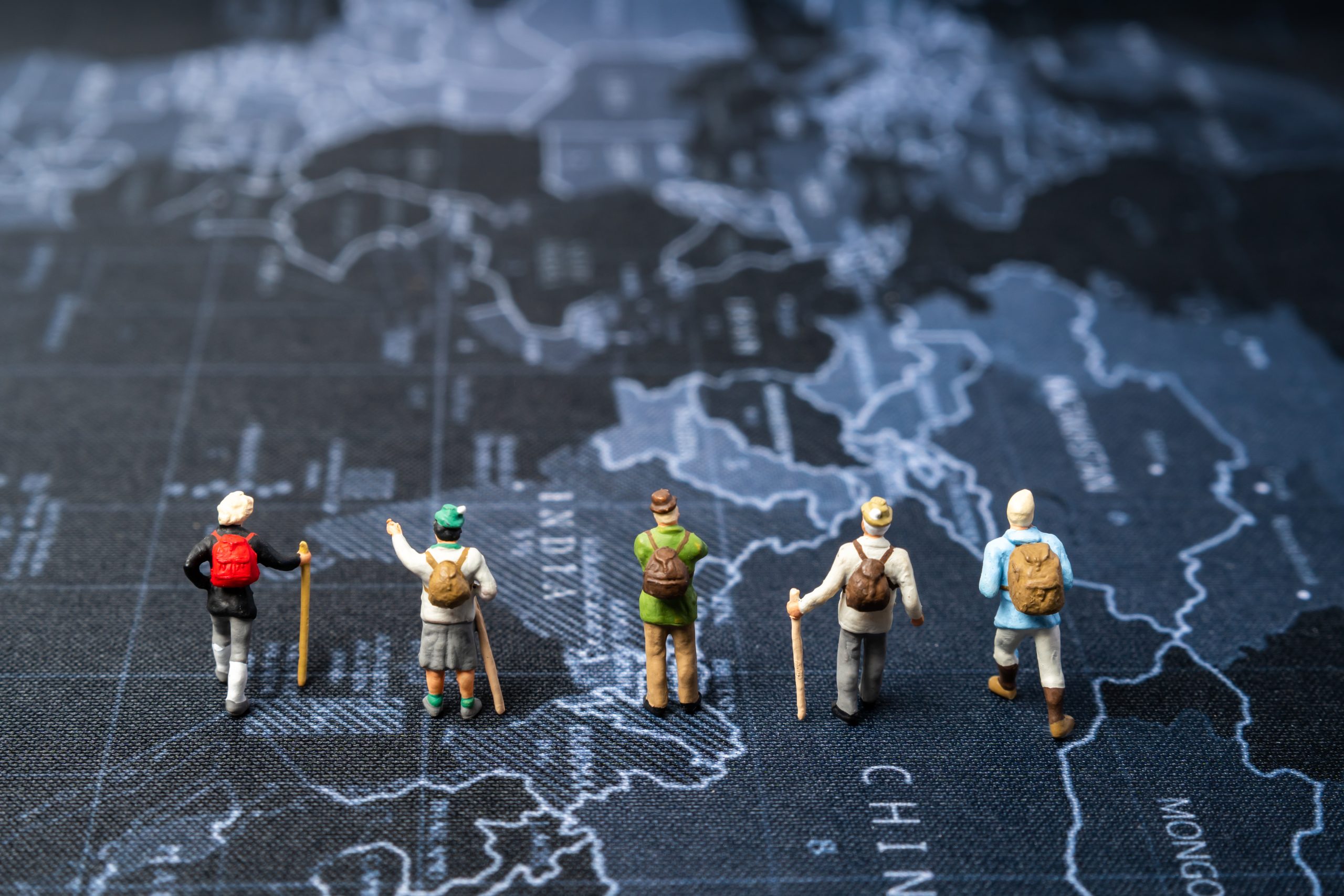 miniature traveler people plan for travel on world map backgroun